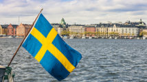 Stockholm view to downtown with a Swedish flag on the waterfront.