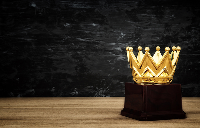 image of golden crown award over wooden table.